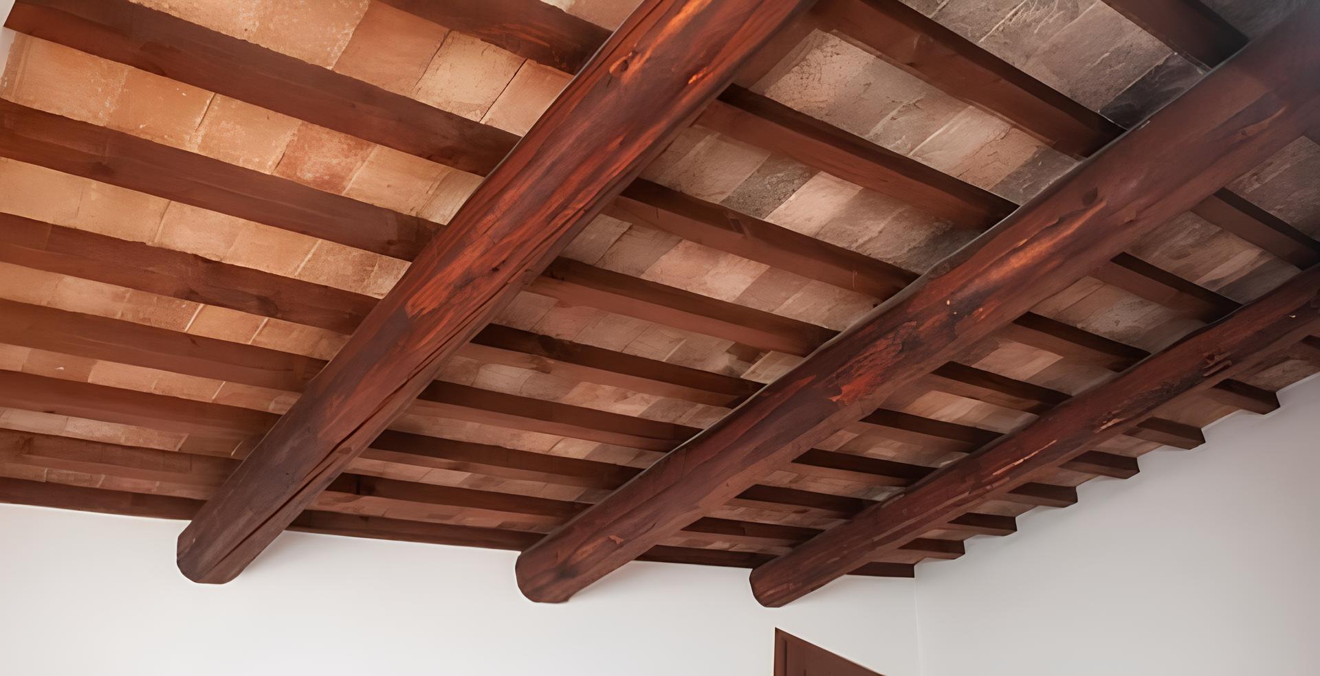 tetto Soffitto con travi in legno massello di colore marrone, disposte parallelamente su parete bianca.